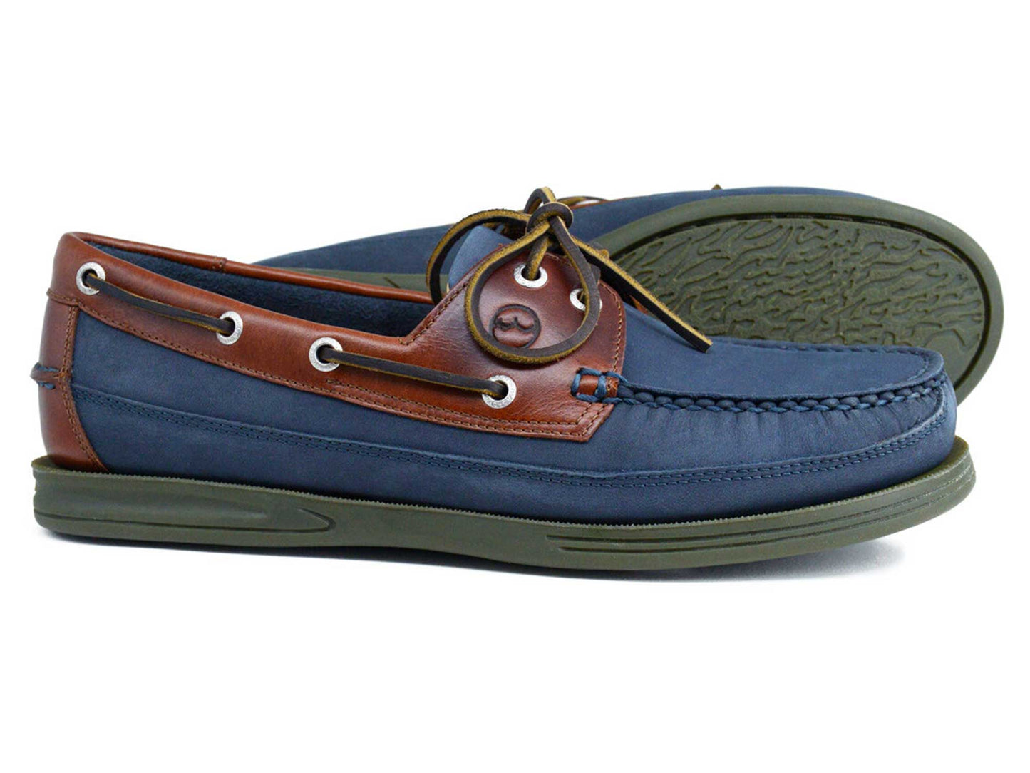 The Orca Bay FOWEY Men's Wide Fitting Deck Shoe in navy nubuck features green slip-resistant rubber soles, tan leather trim, white eyelets, and brown laces. Both shoes are displayed side by side on a white background.