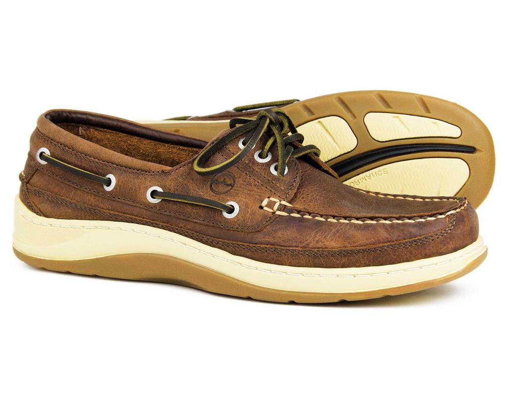 Introducing the Orca Bay Squamish Mens Russet Brown Summer Shoes, crafted with rich brown leather, white stitching, dark green laces, cream soles featuring a textured grip pattern and adorned by a classic side logo for high-performance.