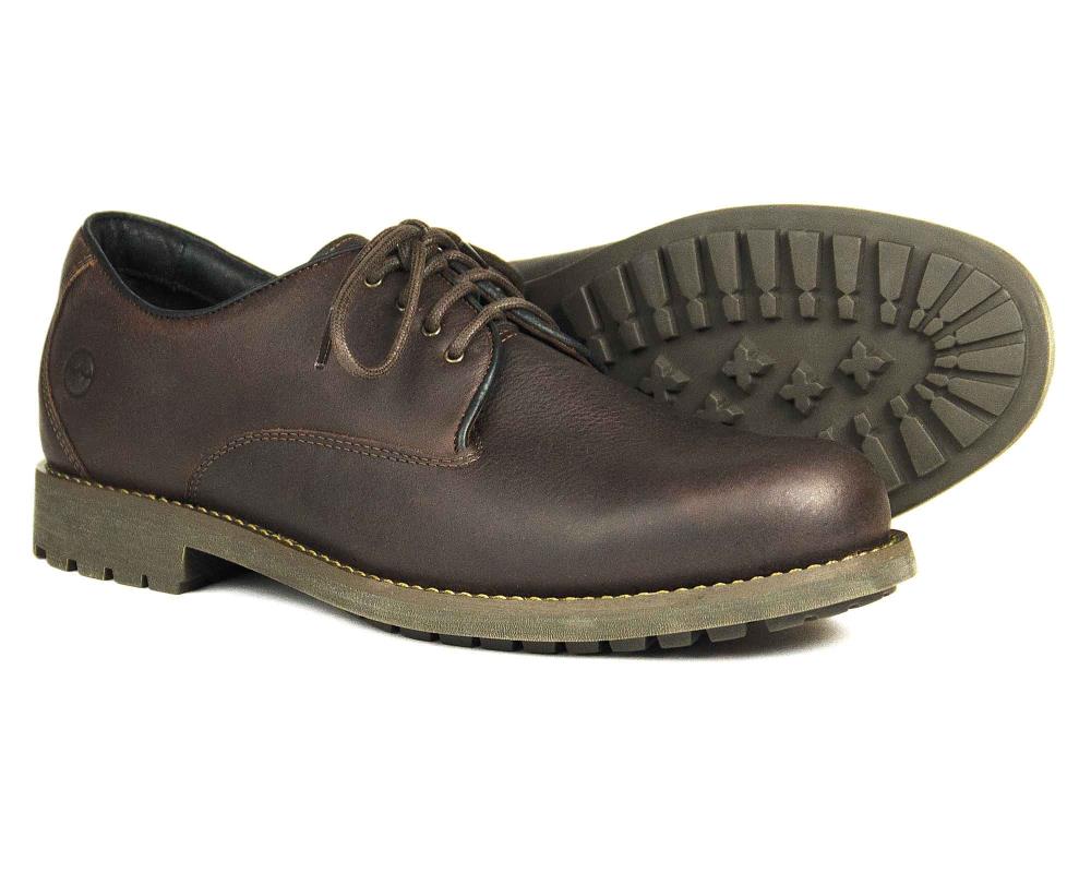 The Orca Bay MALVERN is a men’s dark brown oiled nubuck walking shoe with rugged, durable rubber soles. One shoe stands upright to show the side and front, while the other lies on its side, revealing the tread pattern.