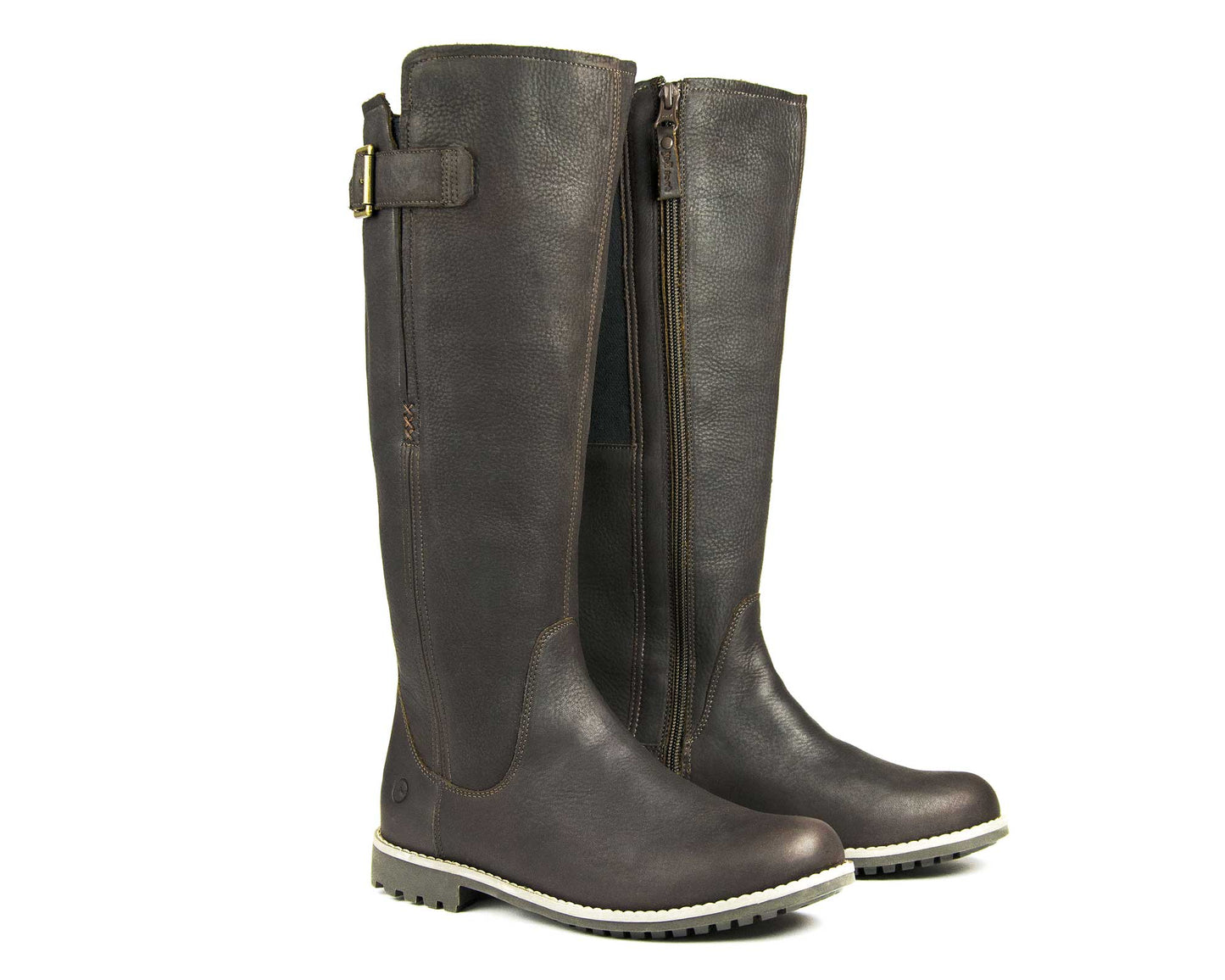 The Orca Bay Ladies Moreton Tall Boot in dark brown leather features side zippers, a decorative top buckle, and light-colored rubber soles. These chic winter boots stand upright side by side.