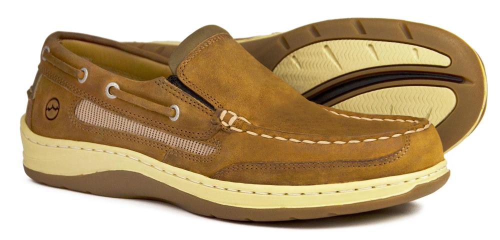 The LARGS Mens Sand Performance Loafer Shoes by Orca Bay feature brown leather, beige mesh panels, white stitching, and cream soles. One shoe stands upright; the other displays its soles tread pattern.