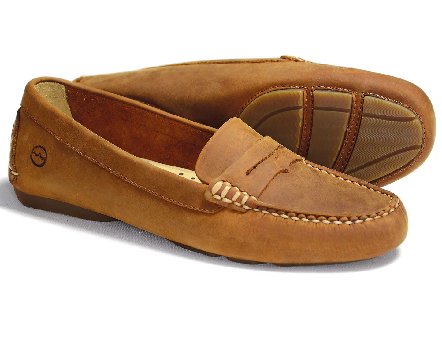 The Richmond Ladies Sand Nubuck Buckled Loafers by Orca Bay feature visible stitching, a small decorative strap on the upper, a textured rubber sole, and a circular emblem near the heel.