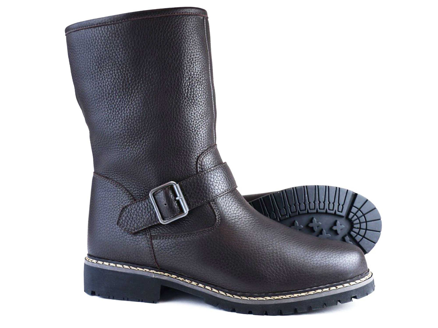 The Orca Bay CONISTON Ladies Dark Brown Fleece Lined Winter Boot is crafted from premium leather, featuring a side buckle and textured sole. Displayed upright and on its side to showcase the tread pattern, this boot blends style with durability.