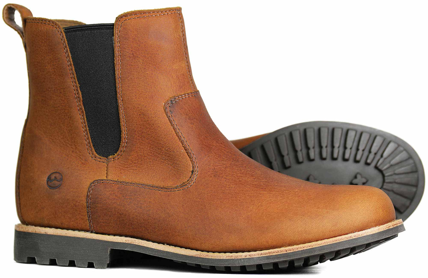 The COTSWOLD Ladies Havana Leather Boots by Orca Bay feature brown water-resistant leather with black elastic side panels and lugged rubber soles. They include a back pull tab and a small logo near the heel, with one boot standing upright and the other tilted on its side.