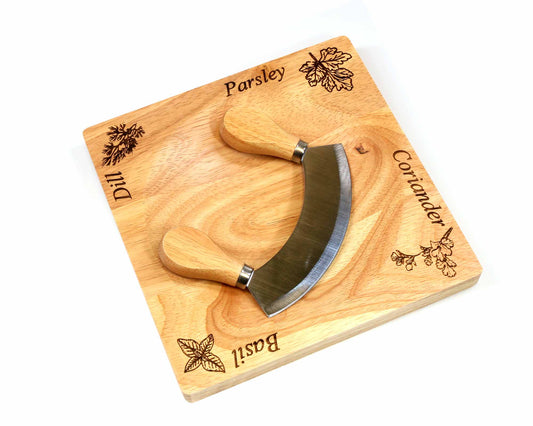 The Cathcart Elliot Mezzaluna wooden herb chopper board features labeled corners for dill, parsley, coriander, and basil, plus a two-handled mezzaluna blade for easy chopping—perfect for personalized herb prep.