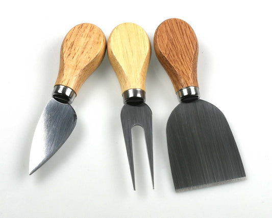 The Cathcart Elliot cheese knife and fork set includes a pointed cheese knife, cheese fork, and wide flat blade with wooden handles, elegantly arranged side by side on a white background.