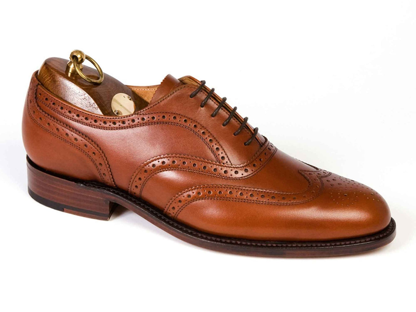The Sanders LONDON Mens Tan Brown Brogue Shoes, crafted from leather with decorative perforations and dark laces, are shown side view with a wooden shoe tree inside against a white background.