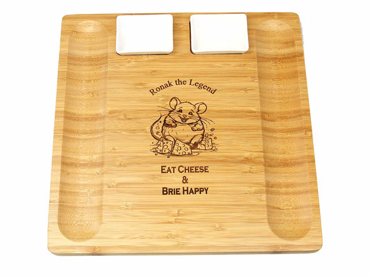 The Cathcart Elliot personalised 33cm x 33cm bamboo cheeseboard and platter server comes with two ceramic dishes, engraved with a cartoon mouse holding cheese and the text Ronak the Legend, Eat Cheese & Brie Happy.