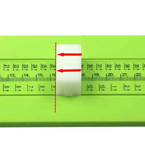 A white slider with red arrows sits on the Cathcart Elliot Green Foot Measure Device by Cathcart Elliot, highlighting a specific measurement with a red dashed vertical line. The clearly visible numbers and units on the ruler make it easy to use as a UK/EU shoe size measuring tool for children to adults (EU 17-51 and UK 2-15), ensuring accurate foot measurements.