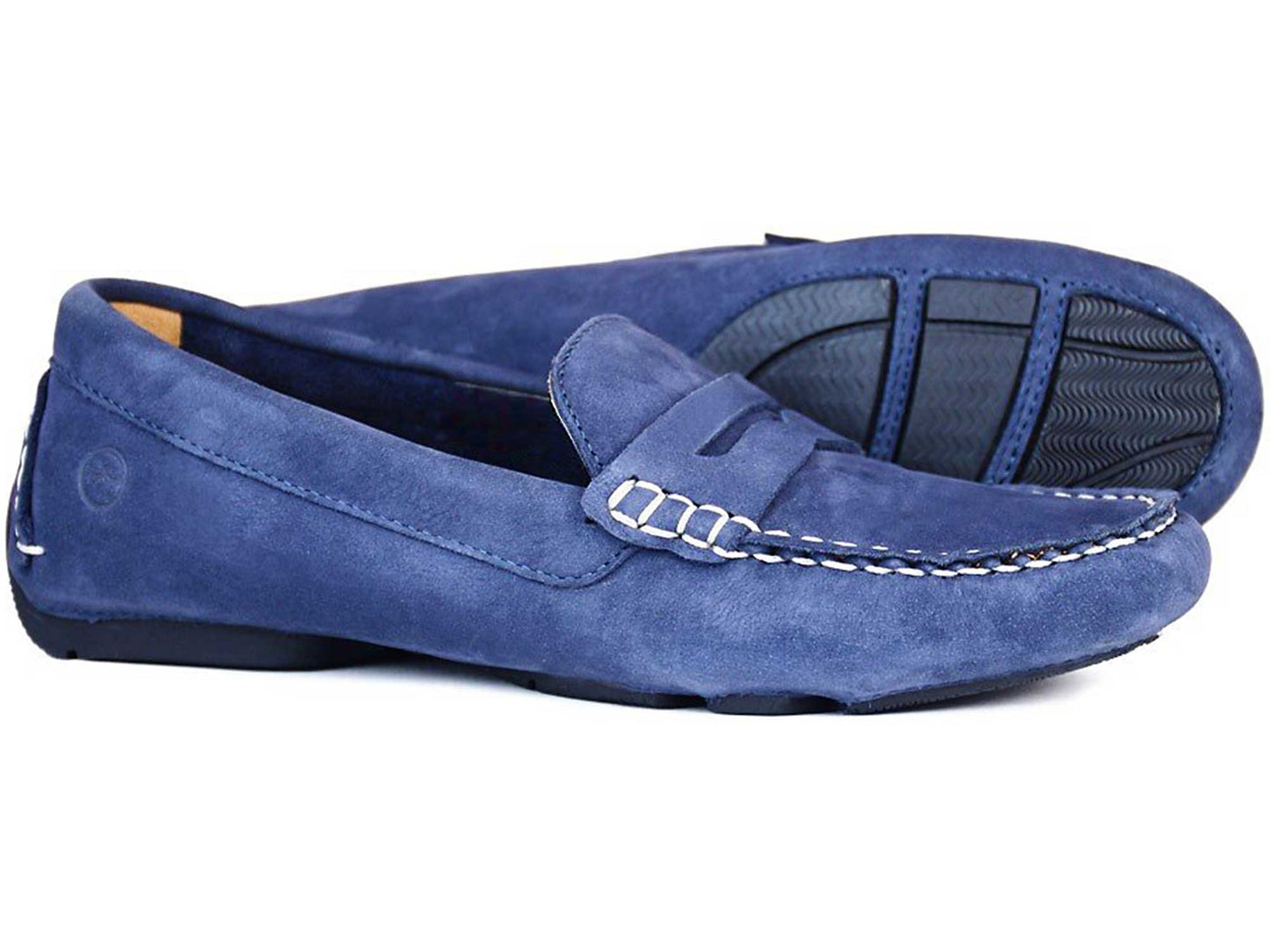 Orca Bays RICHMOND Ladies Indigo Blue Nubuck Buckled Loafers feature stitched detailing, rubber soles, and moccasin construction for added comfort. One shoe is upright and the other on its side, showcasing the tread pattern.