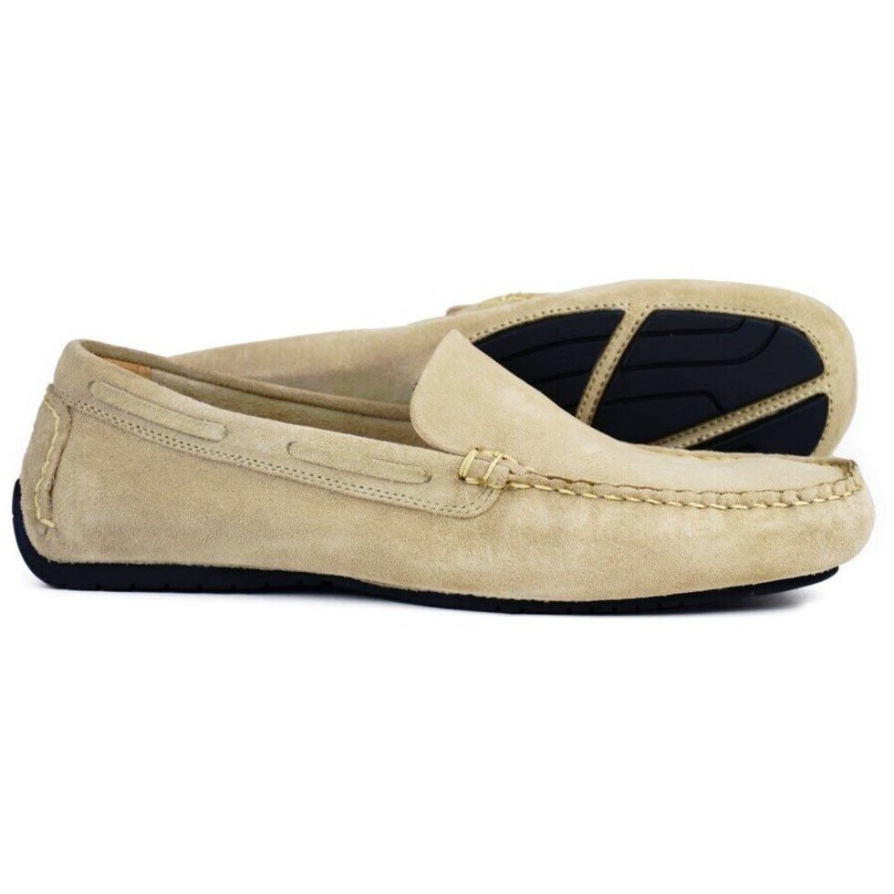 The SILVERSTONE Mens Taupe Suede Leather Driving Shoes by Orca Bay are shown against a white background, with one shoe upright and one on its side. They feature black rubber soles and visible stitching along the sides and front.