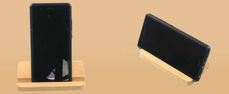 Two smartphones are displayed on wooden stands against a beige background. One phone is upright, and the other is positioned horizontally.