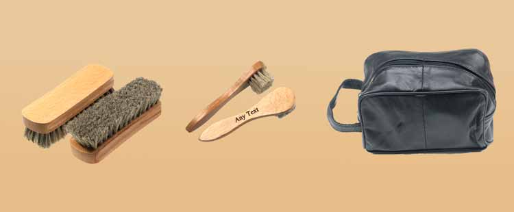 Wooden shoe brushes and a polishing cloth are next to a black leather zippered pouch with a handle against a beige background.