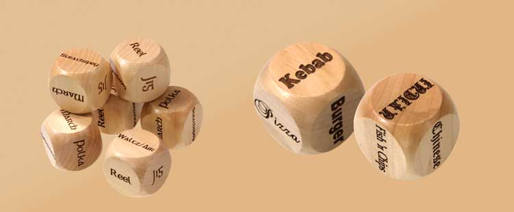 Wooden dice with various text on their faces, such as Kebab, Burger, Sushi, and Jazz, on a light brown background.