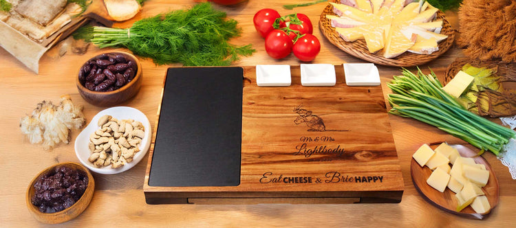 A wooden charcuterie board with a slate section and three ceramic dishes. Engraved with a romantic design and text: Happy 45th Wedding Anniversary Mom & Dad 16/9/1978, Eat Cheese & Brie Happy.