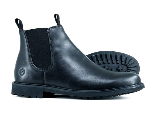 A pair of HENLEY Men’s Ankle Boots by Orca Bay—black leather Chelsea boots with elastic side panels, pull tabs, and thick treaded rubber soles. One boot stands upright; the other is on its side, revealing the sole.