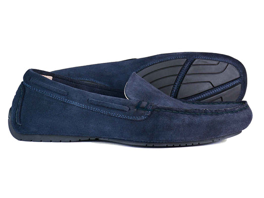 A pair of SILVERSTONE Men's Navy Suede Leather Driving Shoes by Orca Bay, featuring black rubber soles, with one shoe resting on its side and the other standing upright to display the quality leather craftsmanship, detailed stitching, and distinctive textured sole by Orca Bay.