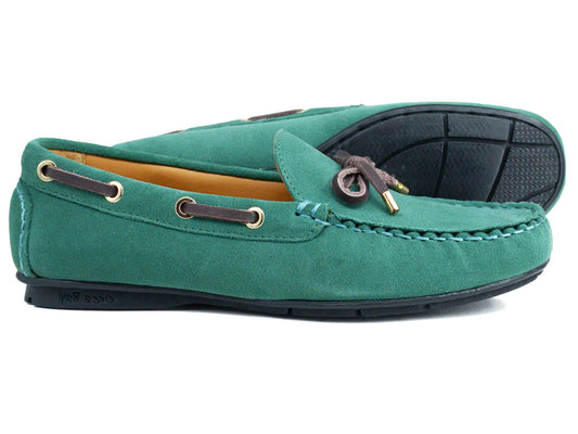 The VIENNA Ladies Green Suede Loafer by Orca Bay features brown leather laces with gold tips, detailed stitching, and black non-slip rubber soles. One shoe lies flat; the other is on its side.