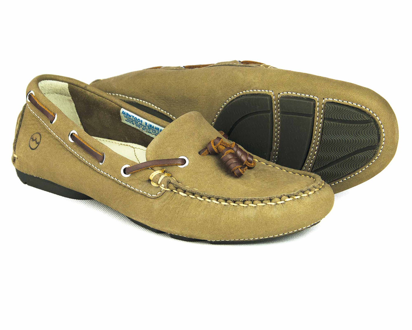 The YARRAWONGA Womens Taupe washable deck shoes by Orca Bay feature soft leather, brown laces, stitching details, and a textured rubber sole. One shoe stands upright while the other highlights its sole.