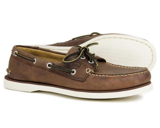 The PORTLAND Mens Orca Bay Deck Shoes in Russet Brown feature premium leather with dark laces, white soles, toe and side stitching. The left shoe showcases the tread pattern, embodying the classic style of Orca Bays mens deck shoes.
