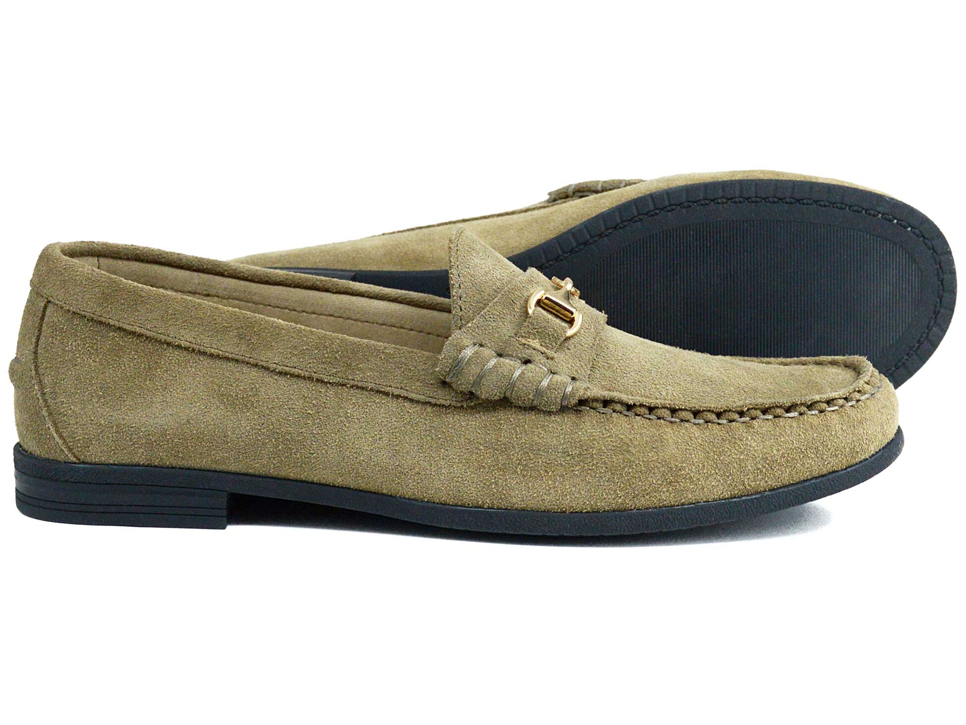 The Orca Bay Zurich Ladies Taupe Suede Buckle Loafer features moccasin-style stitching, black soles, and a small metal buckle on the side. One loafer stands upright while the other is tilted to showcase its sole.