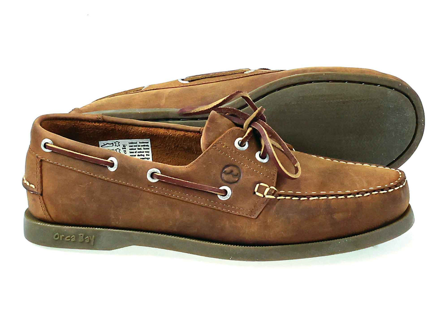 Introducing the Men’s Orca Bay Creek Deck Shoe – Boat Shoe Sand Nubuck by Orca Bay, expertly crafted from sand oiled nubuck leather. This pair features white stitching, lace detailing, and durable rubber soles. Displayed with one shoe upright and the other on its side to reveal the sole, these classic deck shoes from Orca Bay combine timeless style with lasting comfort.