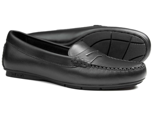 The FLORENCE Ladies Black Calf Loafer by Orca Bay offers a sleek, classic design with black leather uppers, stitching detail, and rubber soles. The slip-on style and subtle seam make them ideal driving shoes for any occasion.