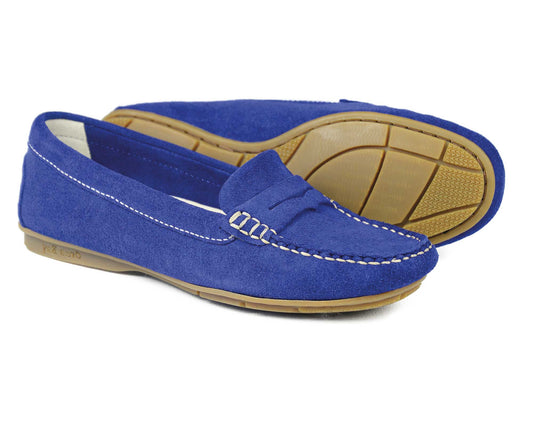 The FLORENCE Ladies Cobalt Suede Summer Loafer by Orca Bay features white stitching and tan rubber soles. Displayed with one upright, the other on its side, showcasing their chic sole design, perfect as versatile driving shoes for summer occasions.