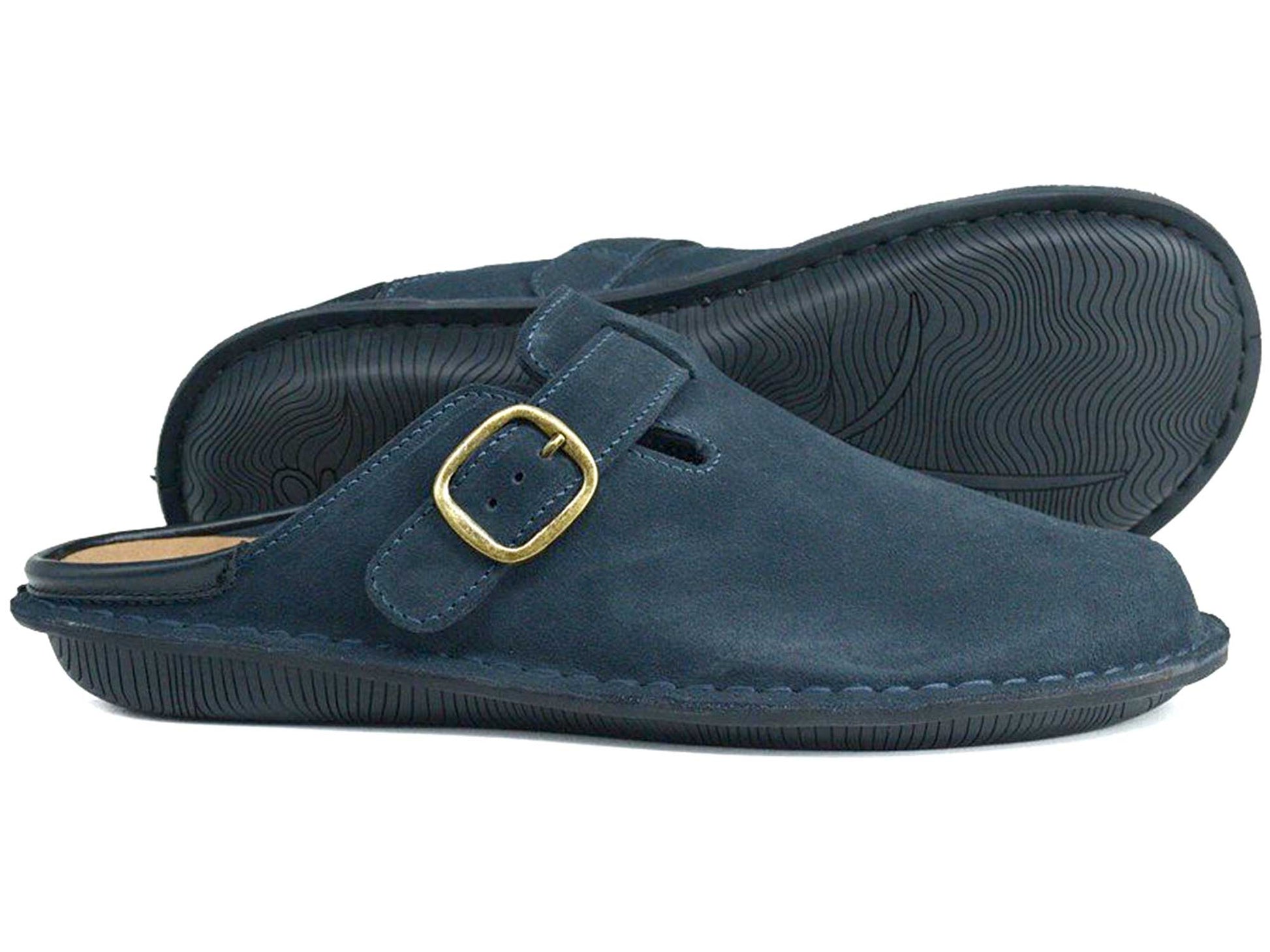 The Orca Bay Garda Navy Blue Suede Clog Mule features a unisex design with black rubber soles and a gold buckle side strap. One shoe stands upright, while the other lies on its side, showing the textured sole.