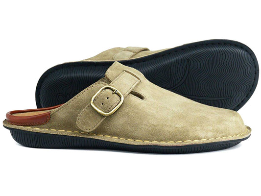 The Orca Bay Garda Taupe Suede Clog Mule features an adjustable strap, black textured rubber soles, and tan stitching. One unisex mule from the Orca Bay brand stands upright while the other lies on its side in the background.