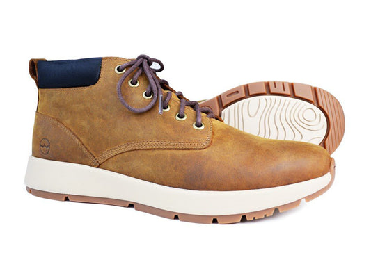 Orca Bay’s KIELDER Men’s Sand Brown Waterproof Boot has oiled nubuck leather, a contrasting white and tan rubber sole, visible eyelets with brown laces on one boot, while the other displays the patterned sole and navy blue fabric detail at the heel.