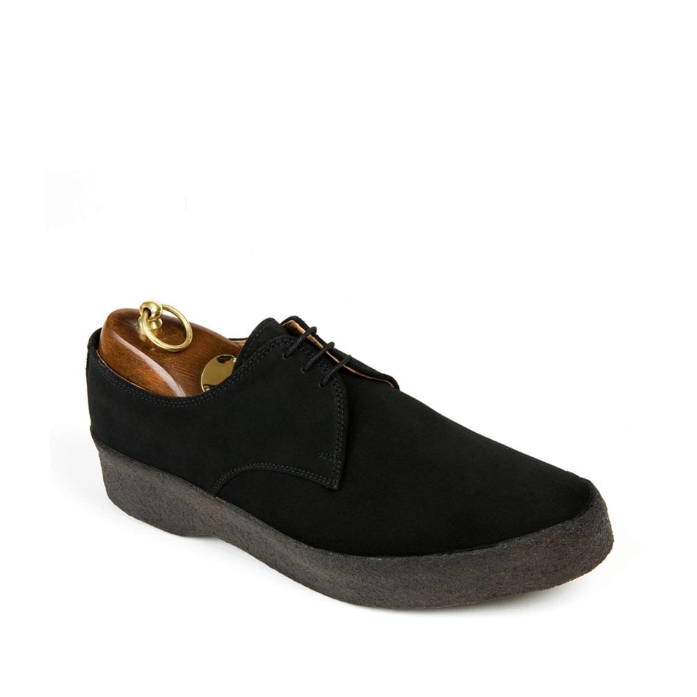The Sanders LO-TOP Mens Black Suede Shoes feature a thick, textured crepe sole, brown leather lining, and a brass shoehorn at the heel. This Gibson Shoe showcases minimalistic design with black laces, elegantly contrasting against a white background.