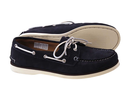 The PORTLAND Navy Blue Suede Boat Shoe by Orca Bay features premium suede uppers, white stitching, white laces, and contrasting white soles. One shoe stands upright while the other lies on its side, showcasing its sole and craftsmanship.