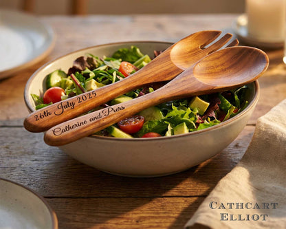 A salad bowl with greens, tomatoes, and cucumbers, served with Cathcart Elliot's Personalised Set of 2 Acacia Wood Salad Spoon and Fork Servers (25cm), engraved with "26th July 2025" and "Catherine and Piers".