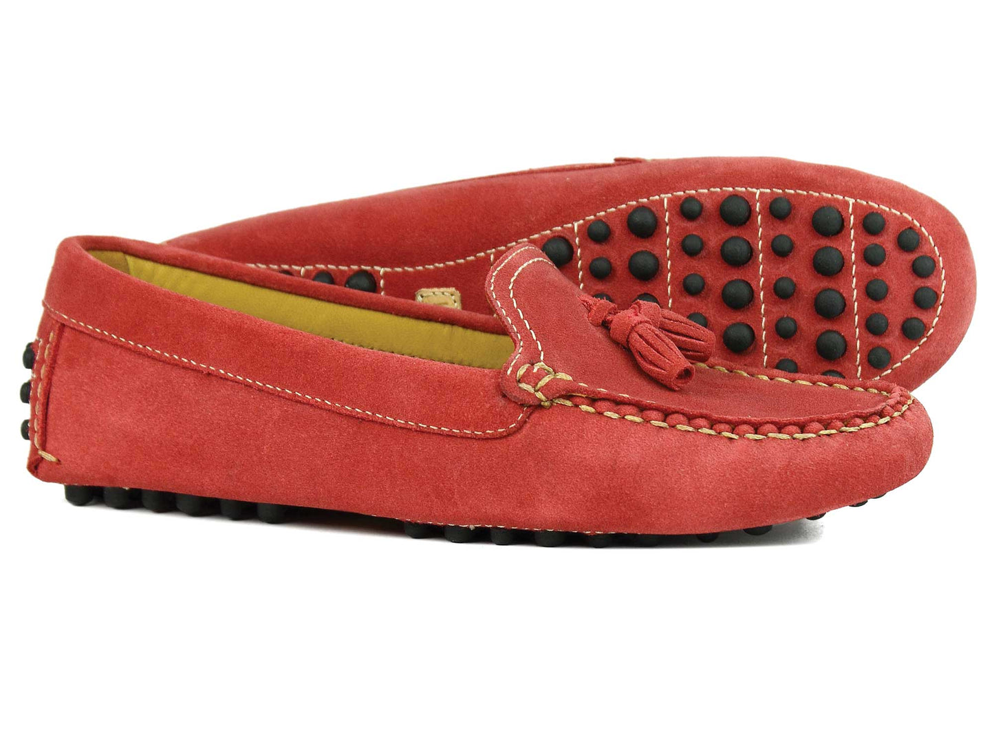 The SALE SALCOMBE Ladies Red Suede Driving Loafers by Orca Bay feature tassels, visible white stitching, and black rubber nubs on the non-slip soles for excellent traction. One shoe stands upright while the other is laid on its side to showcase its exquisite details.