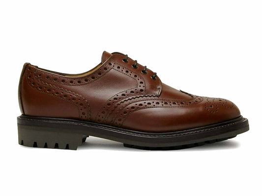 The SALISBURY Mens Brown Waxy Brogue with Rubber Sole by Sanders is crafted from waxy leather, featuring decorative perforations, black laces, and a chunky commando rubber sole. The shoe is elegantly showcased in its side profile on a plain white background.