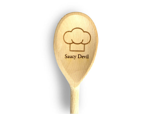 Cathcart Elliot presents a personalised wooden spoon featuring a chefs hat design and Saucy Devil elegantly engraved on the handle, set against a pristine white background.