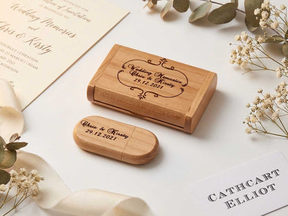 The Cathcart Elliot Personalised Maple Wood 16GB USB 3.0 with matching engraved gift box is shown on a light surface, surrounded by invitations, ribbon, and dried flowers. Engraving reads: “Wedding Memories Chris & Kirsty 29.12.2021.”.